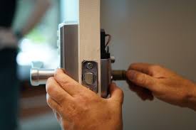 Hands adjusting a door lock mechanism with tools during a lock repairLocksmith Near Me
